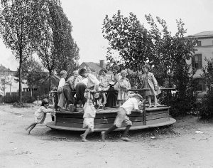 A picture of children playng on a roundabout.