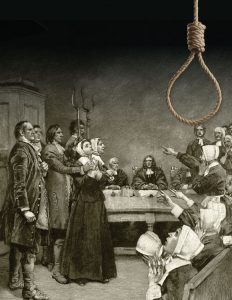 A picture of men bringing in a witch-causes of the Salem witch trials