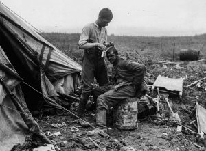 A picture depicting a British troop dressing the wounds of a German prisoner