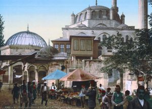 A colour picture depicting a mosque and the street market in Constantinople.