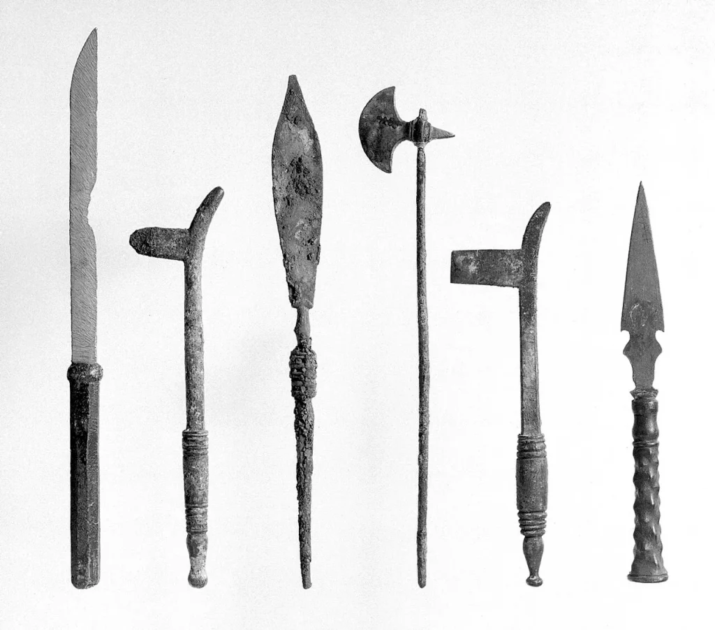 Set of bronze surgical instruments including scalpels and probes, similar to the tools used by ancient surgeons.