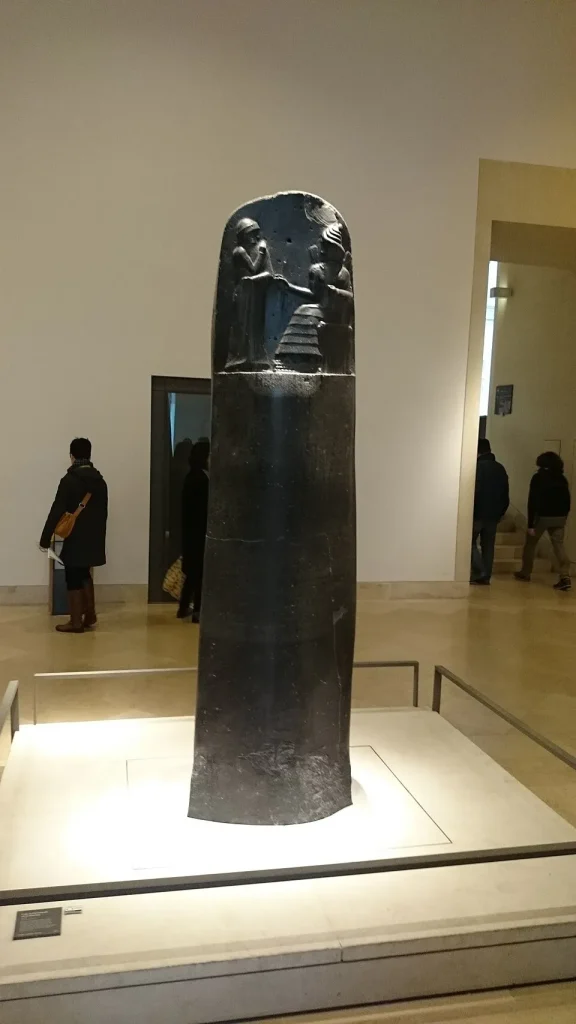 The basalt stele of the Code of Hammurabi in the Louvre Museum, showing the carved laws that first regulated surgery and medical liability.